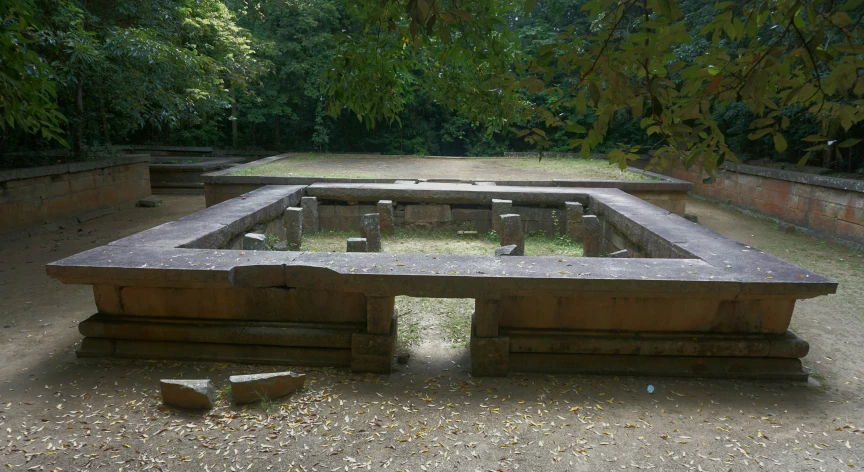 there is a long bench in the middle of a concrete area