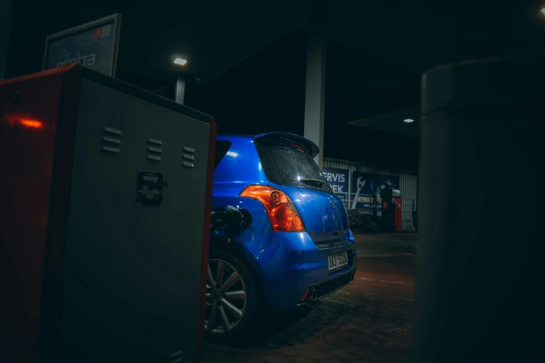 a blue car is parked in front of an electrical box