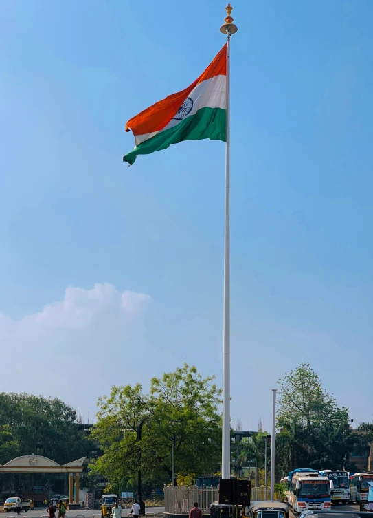 a flag pole with a white, orange, and green state of india flag flying