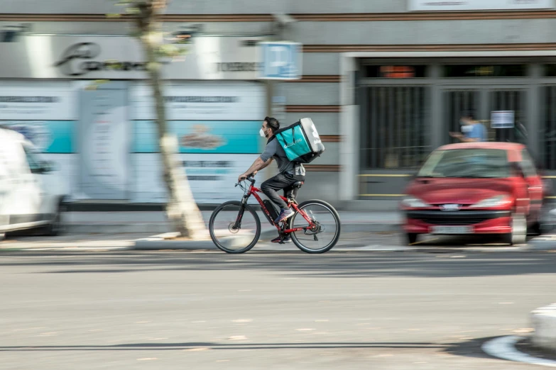 a man with a backpack on his back rides a bike