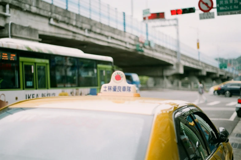 the taxi is stopped at the yellow light on the busy street