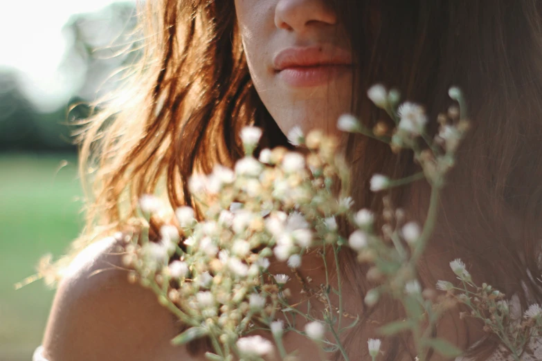 a woman with long hair looking at flowers
