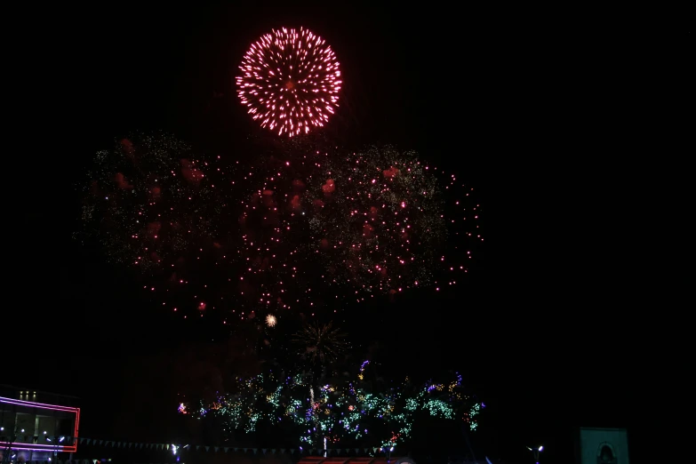 fireworks are lit up over the crowd at night