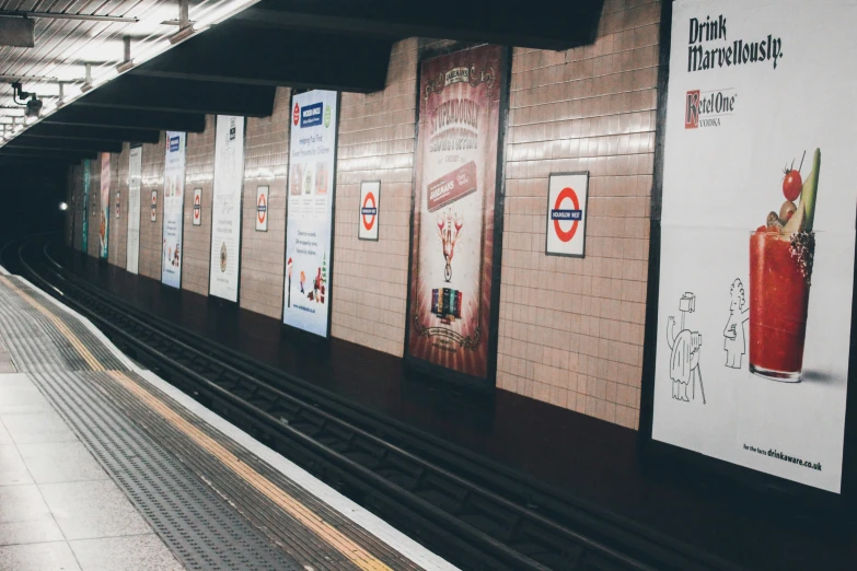 a subway station with several posters on the side