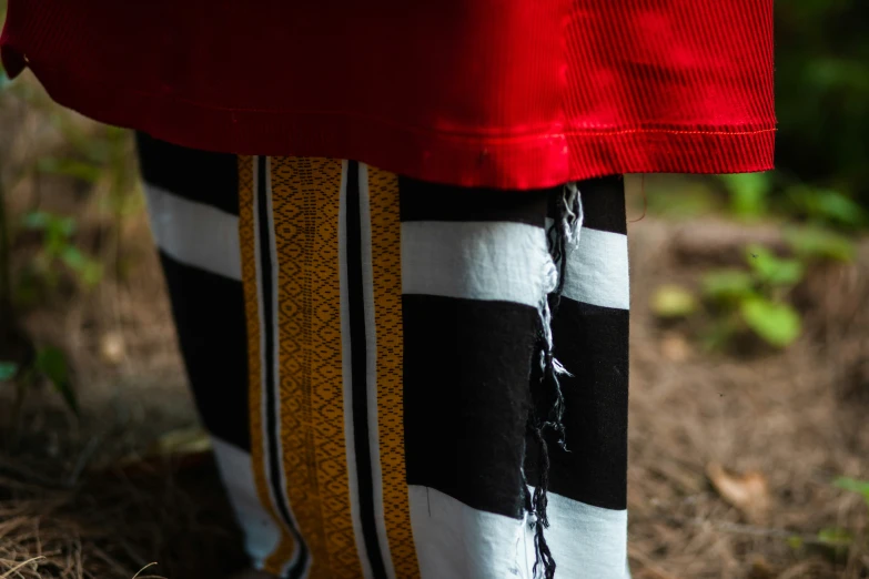 a woman wearing a red coat and black and white pants