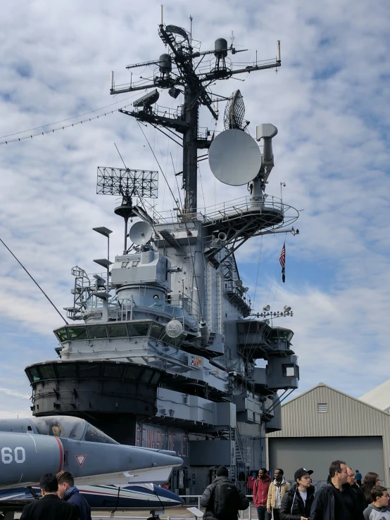 military aircraft in formation on the deck of a large aircraft carrier