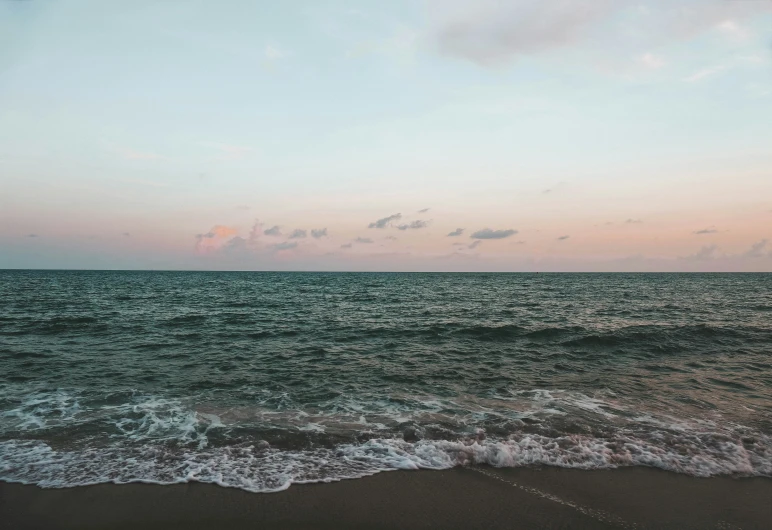 the sun is setting over the ocean water