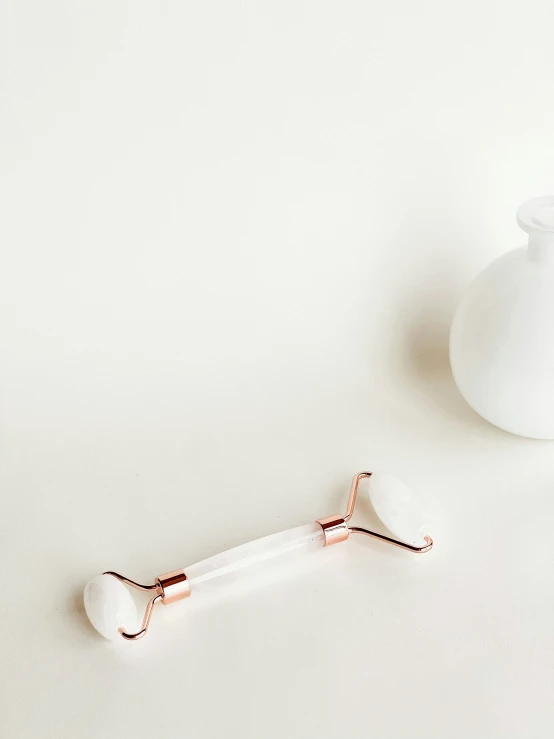 small white vase with a rose gold nose ring