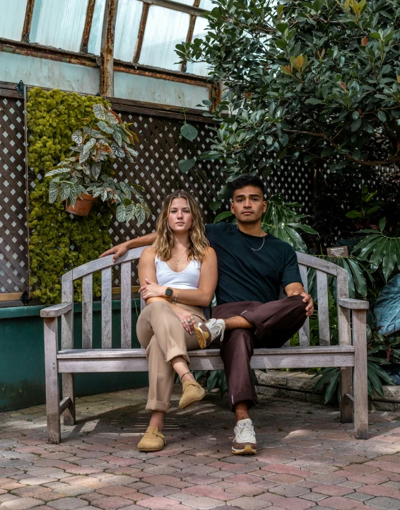 a man and woman are sitting on a wooden bench