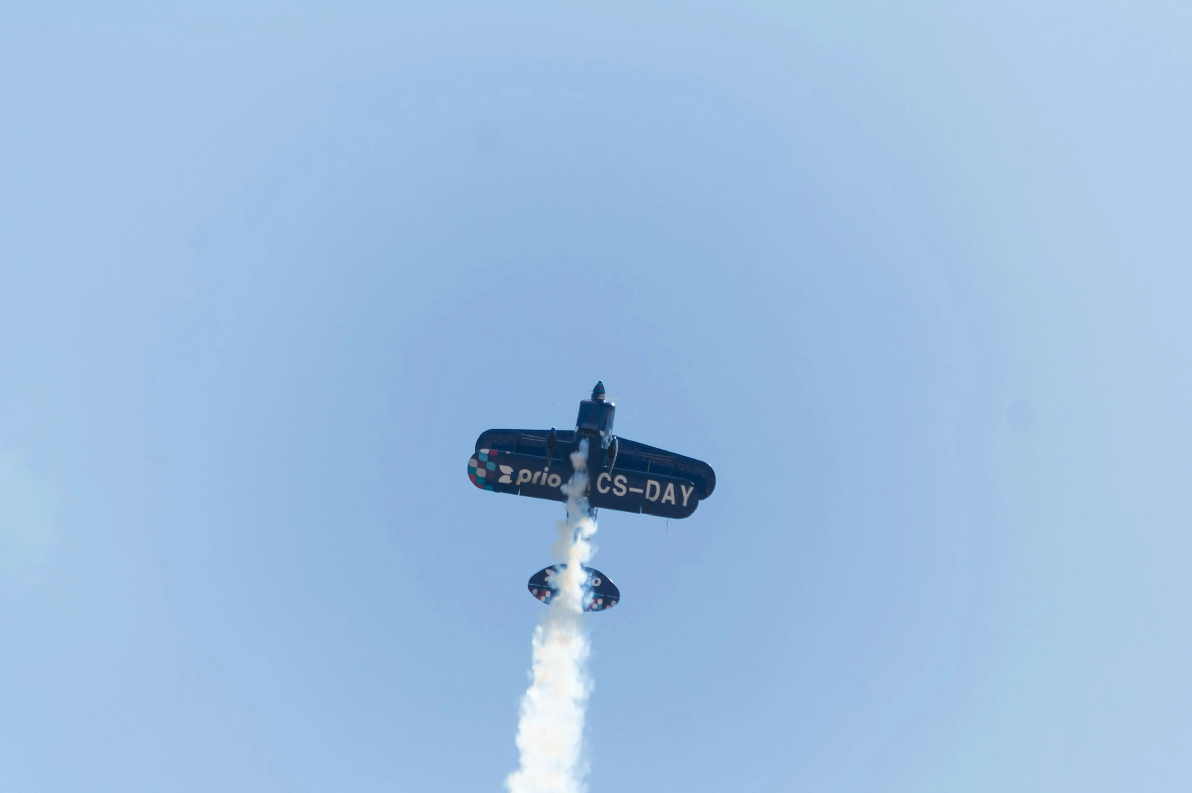 an airplane with smoke flying in the air