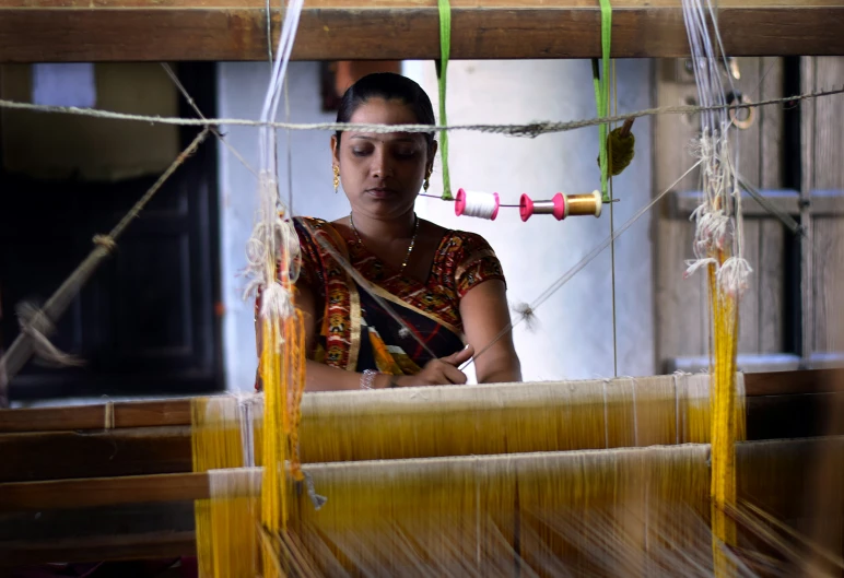 a woman is working on some weaves in a house