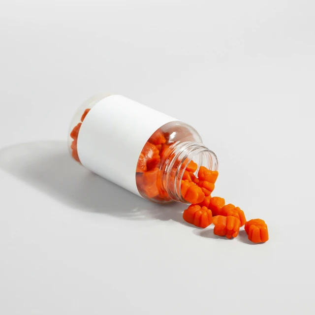 a single pill bottle filled with tiny orange pills