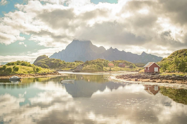 a house by the water with mountains behind