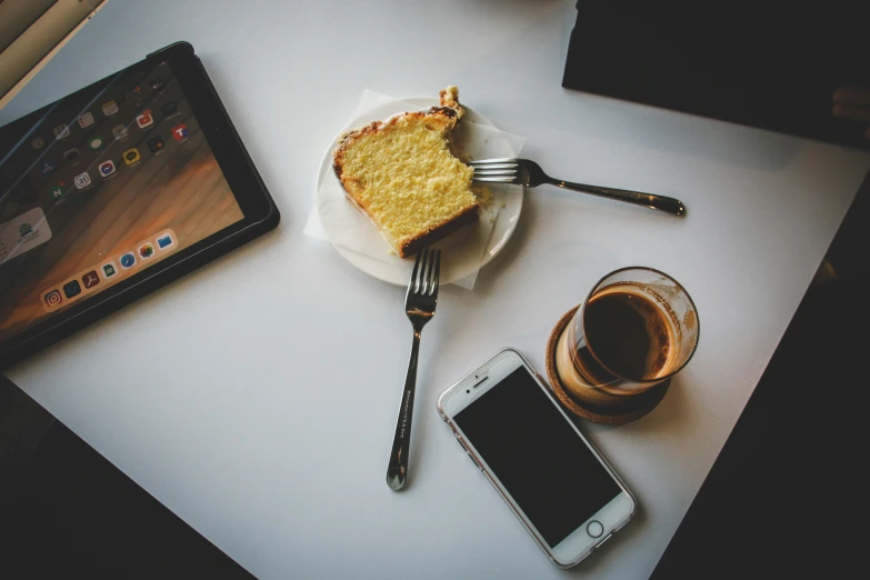 the plate has been left out and is next to a cell phone, a smart phone and fork