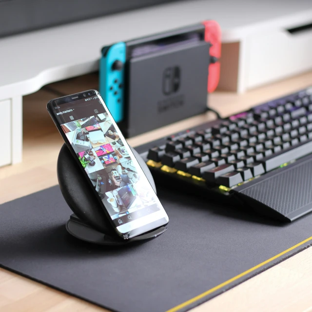 a close up of a controller and a phone near a keyboard