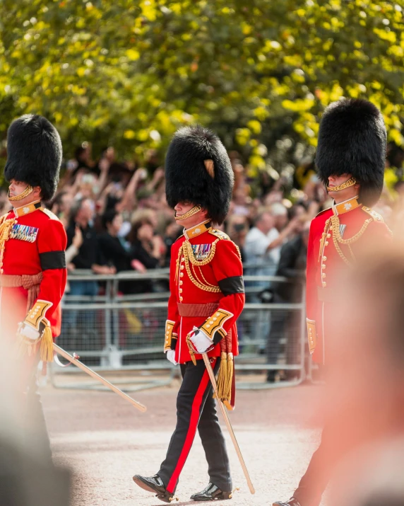 the guards of the british royal family wave as they walk past spectators