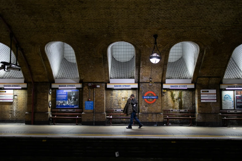 a man is walking in the evening by a train station