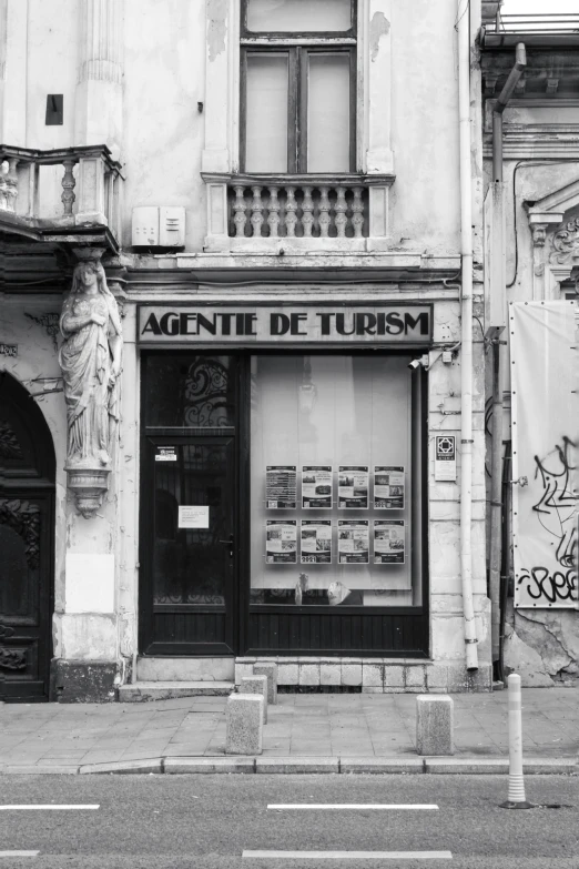 an empty street corner with a sign in the window and graffiti on the wall