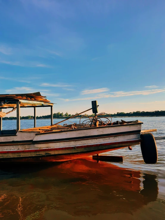 an old boat is standing on a beach next to the water