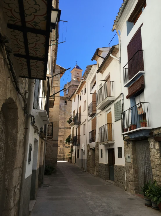 an empty alley with buildings and railings in an old town