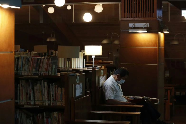 a person sitting in the liry reading a book