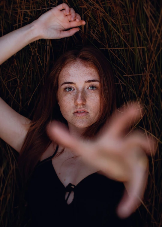 a beautiful young woman holding her hair behind her shoulders