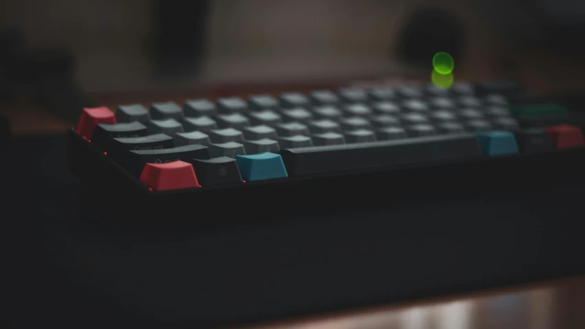 a red, black and blue keyboard that appears to be on a desk