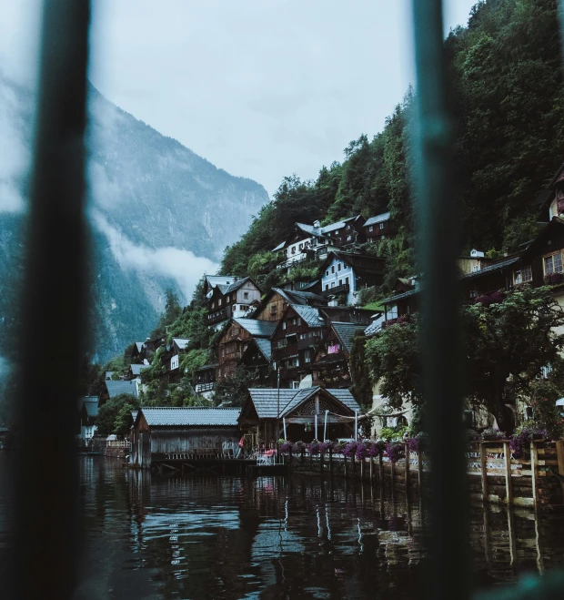 the town on the shore of a lake with trees in it