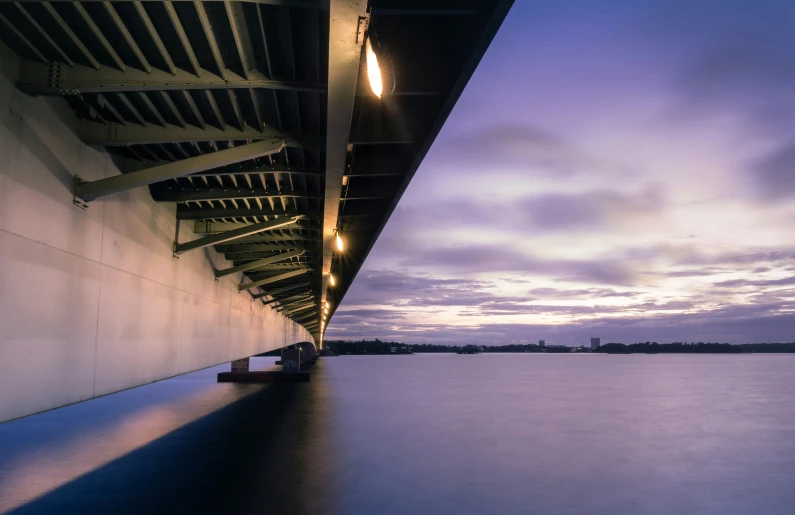 the view from below a bridge overlooking a large body of water