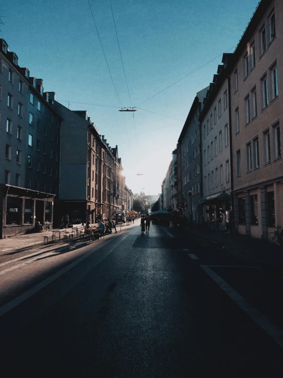 a road with buildings and people walking down the street