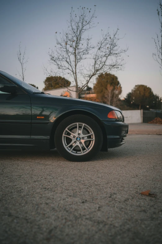 a dark colored car sits parked in a parking lot