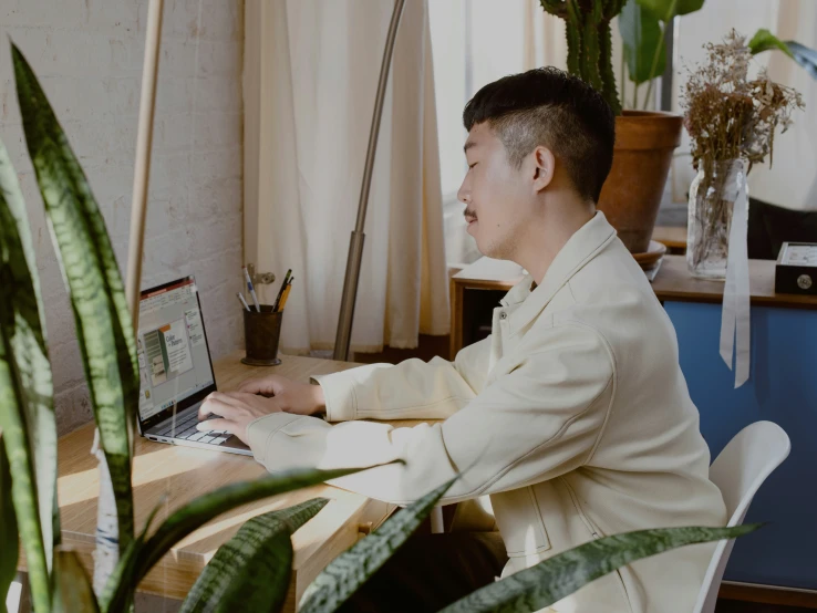 a young man sitting at his desk typing on a computer