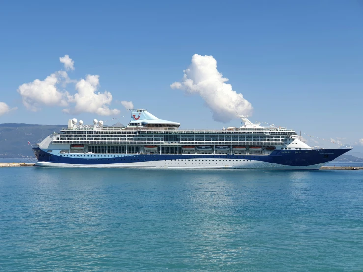 a cruise ship sails through the ocean under a partly cloudy sky