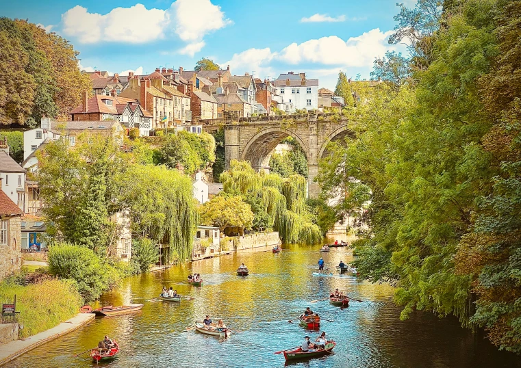 canoes are going down the water beneath an old stone bridge