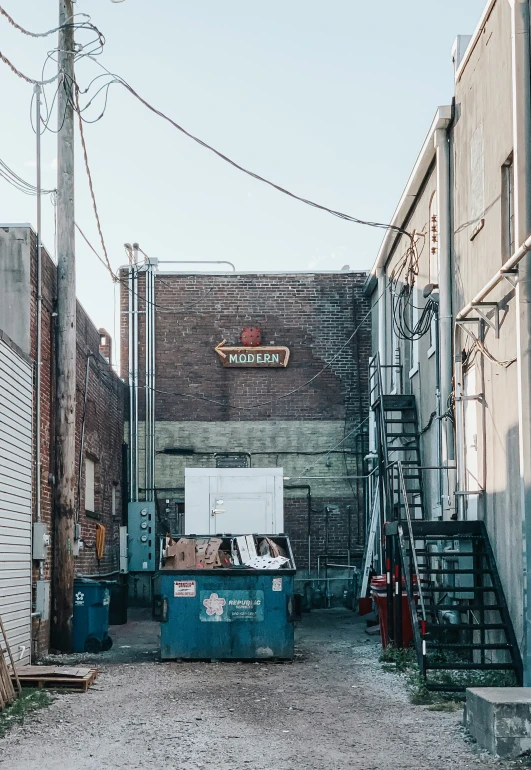 an alley with a tall brick building and graffiti written on it