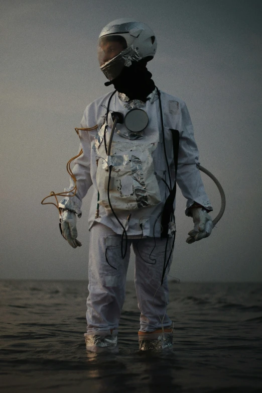 a man in white space suit standing on the beach