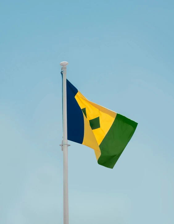 the flag of jamaica flying on a pole