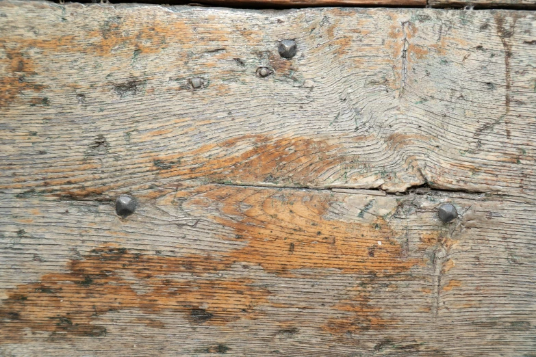 an old wooden plank with nails on it