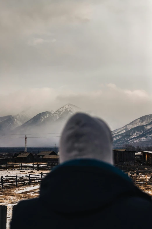 a person with a coat on and a mountain in the background