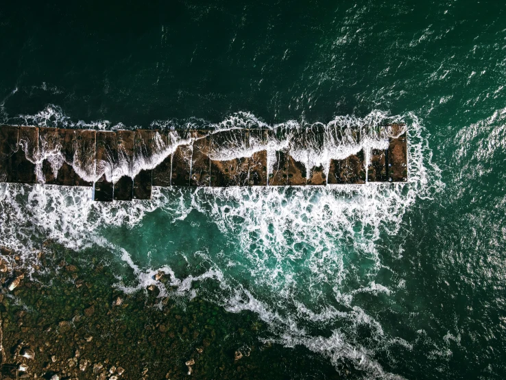 the side of a pier surrounded by waves