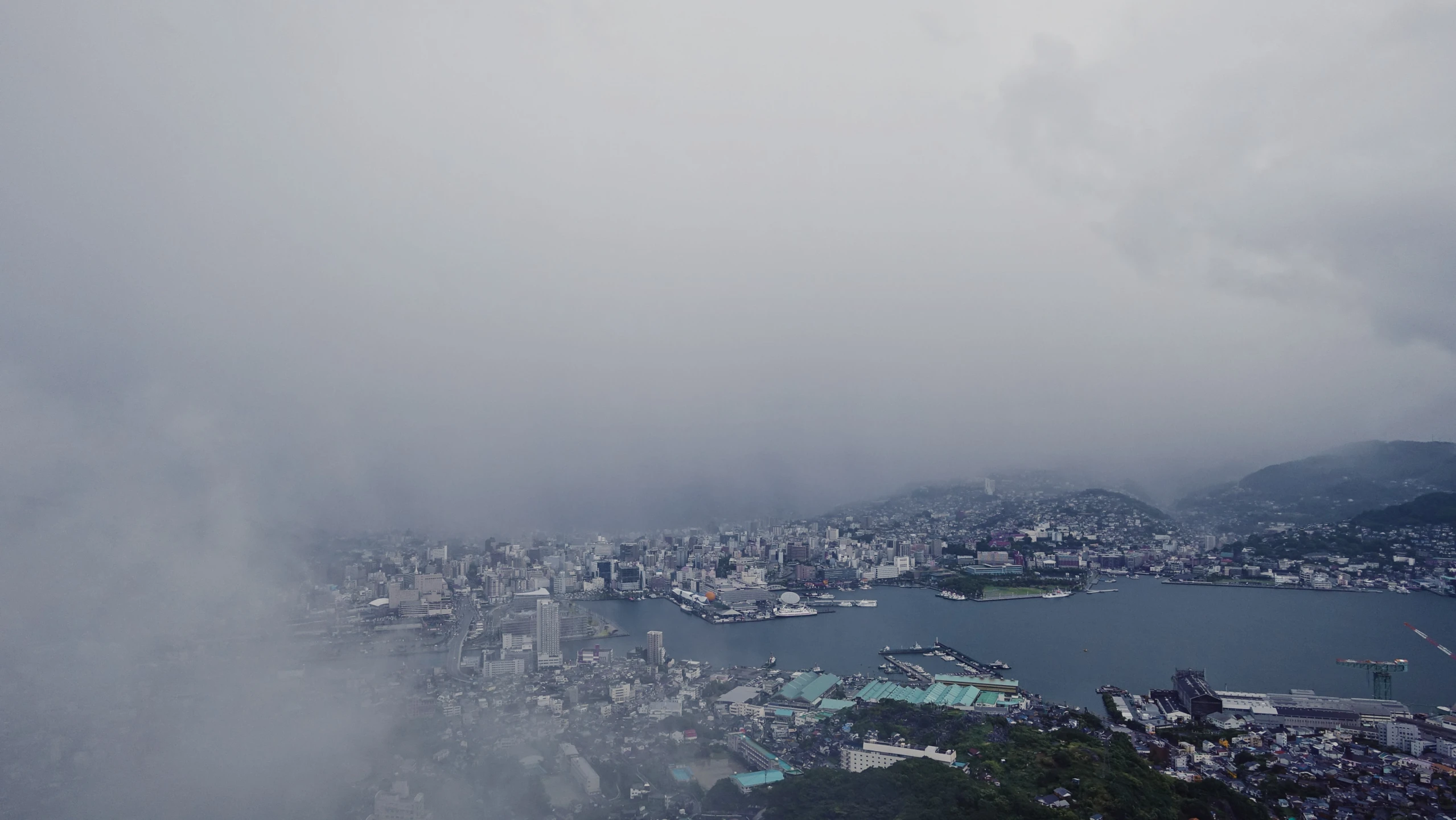 a view of a city surrounded by water and mountains