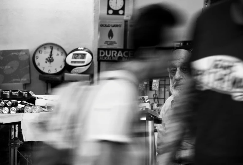 a person sitting at a table in front of a clock