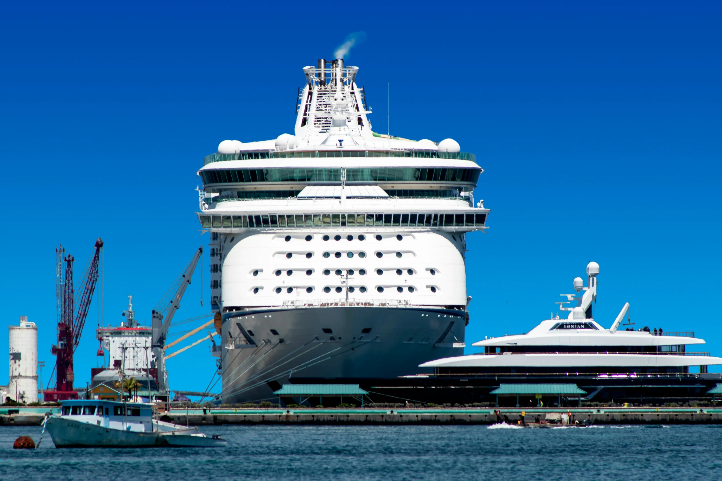 the big cruise ship has been docked with smaller boats