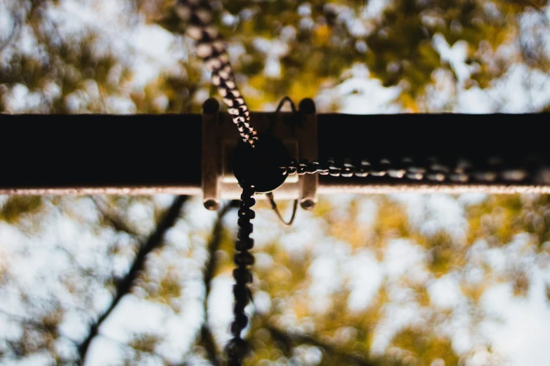 a metal pipe and wires going up and down in front of trees