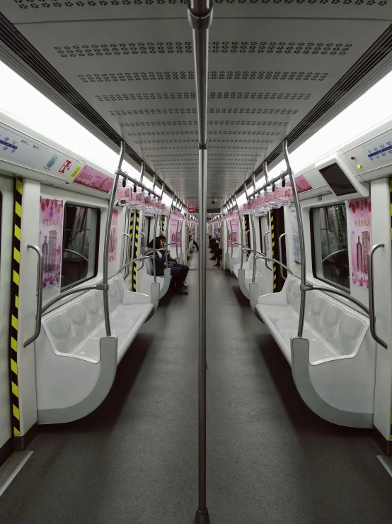 the inside of a subway car that has pink letters on it