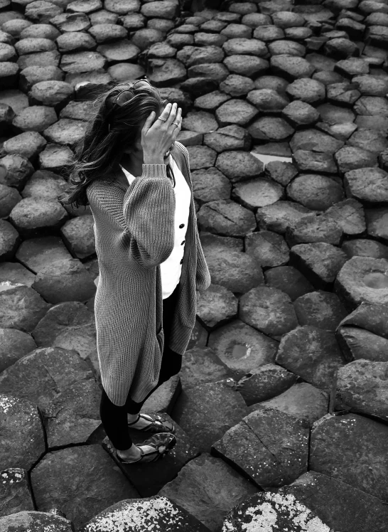 a little girl is standing on rocks and looking up