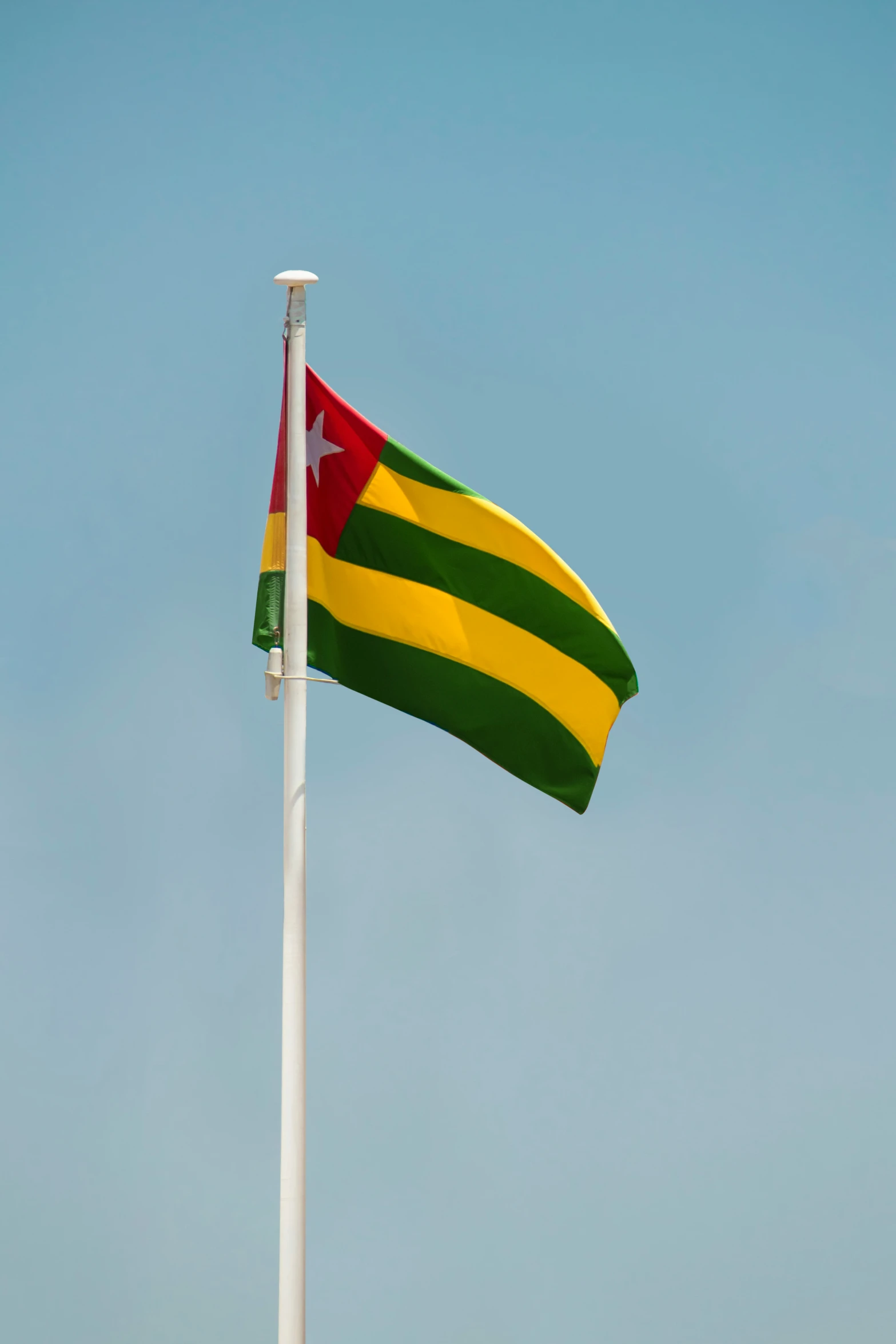 a flag on top of a pole next to the ocean