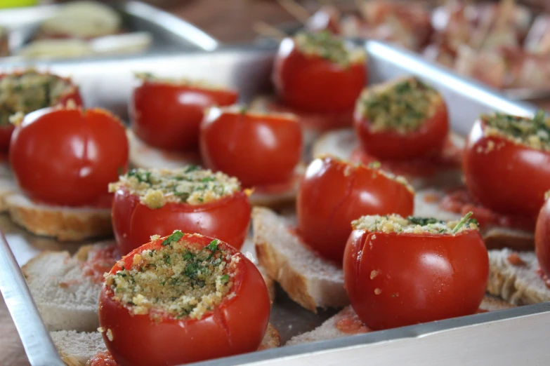 a tray full of tomatoes stuffed on bread