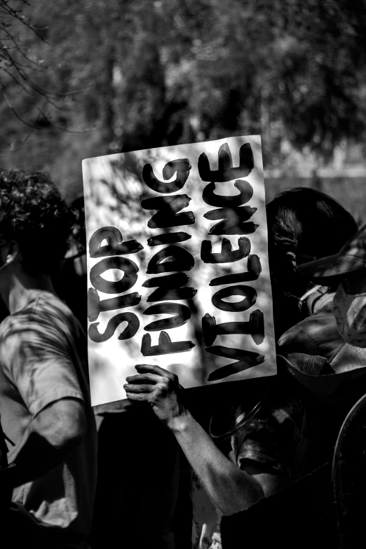 a person holding up a sign that reads peace and justice