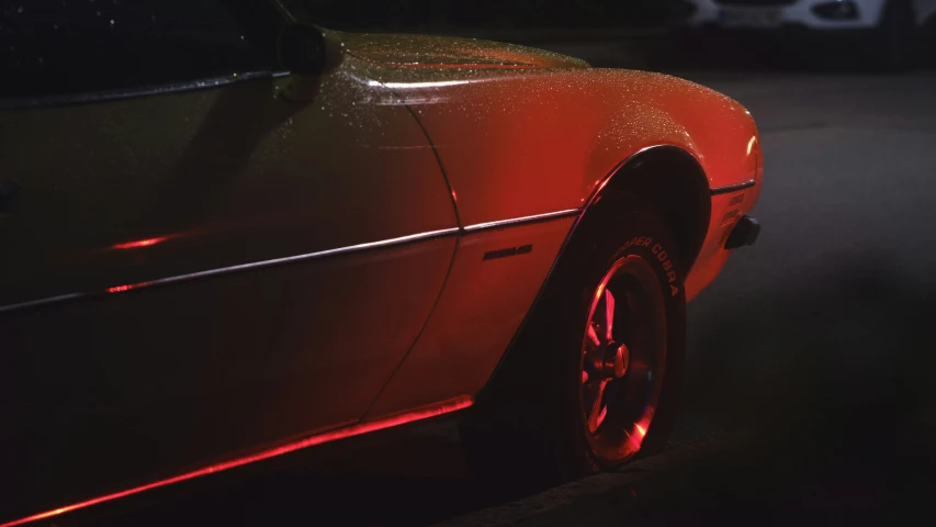 the side view of a car with red light shining from the windows